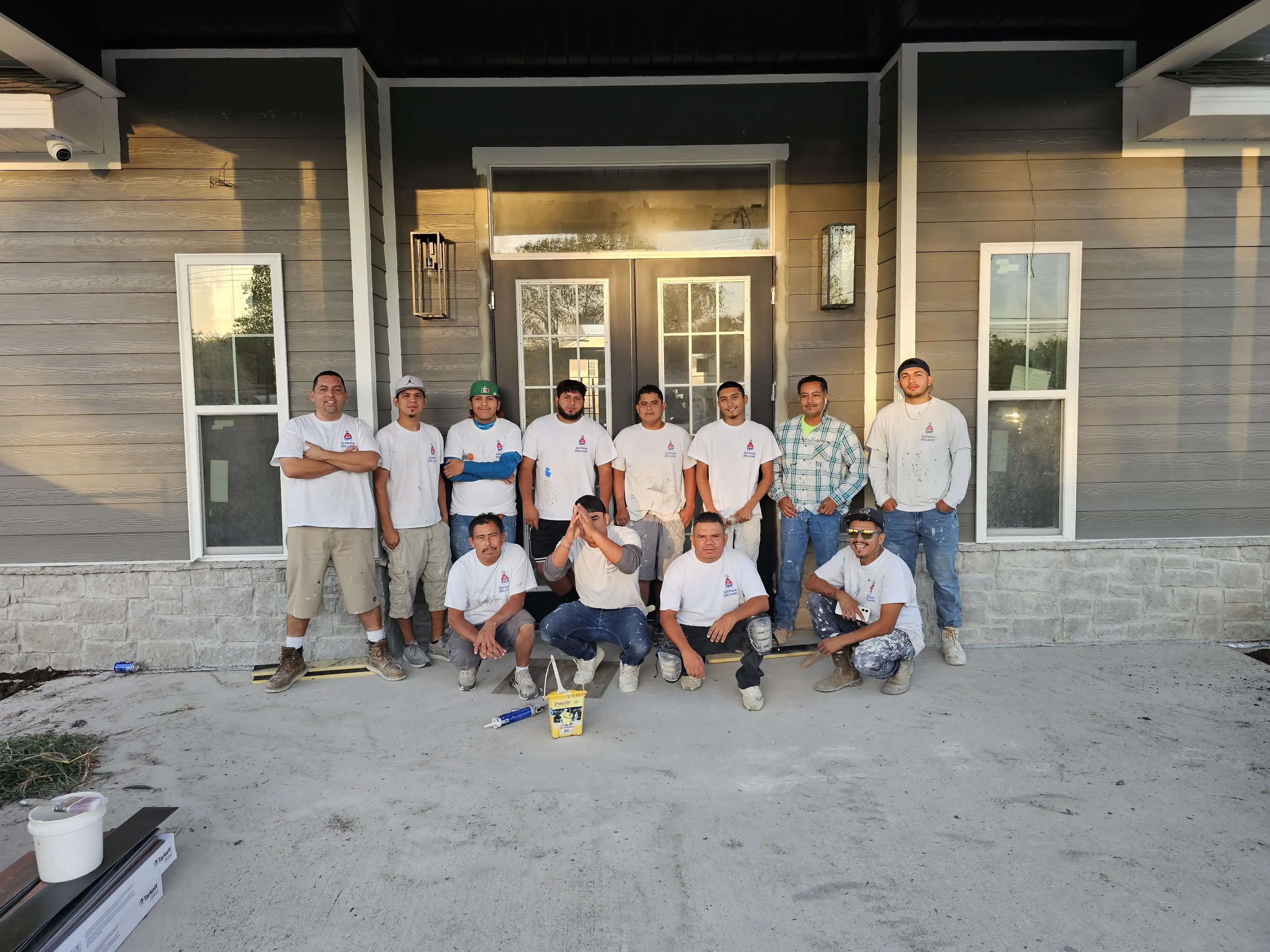 Ric's Professional Painting team members posing in front of a completed residential project